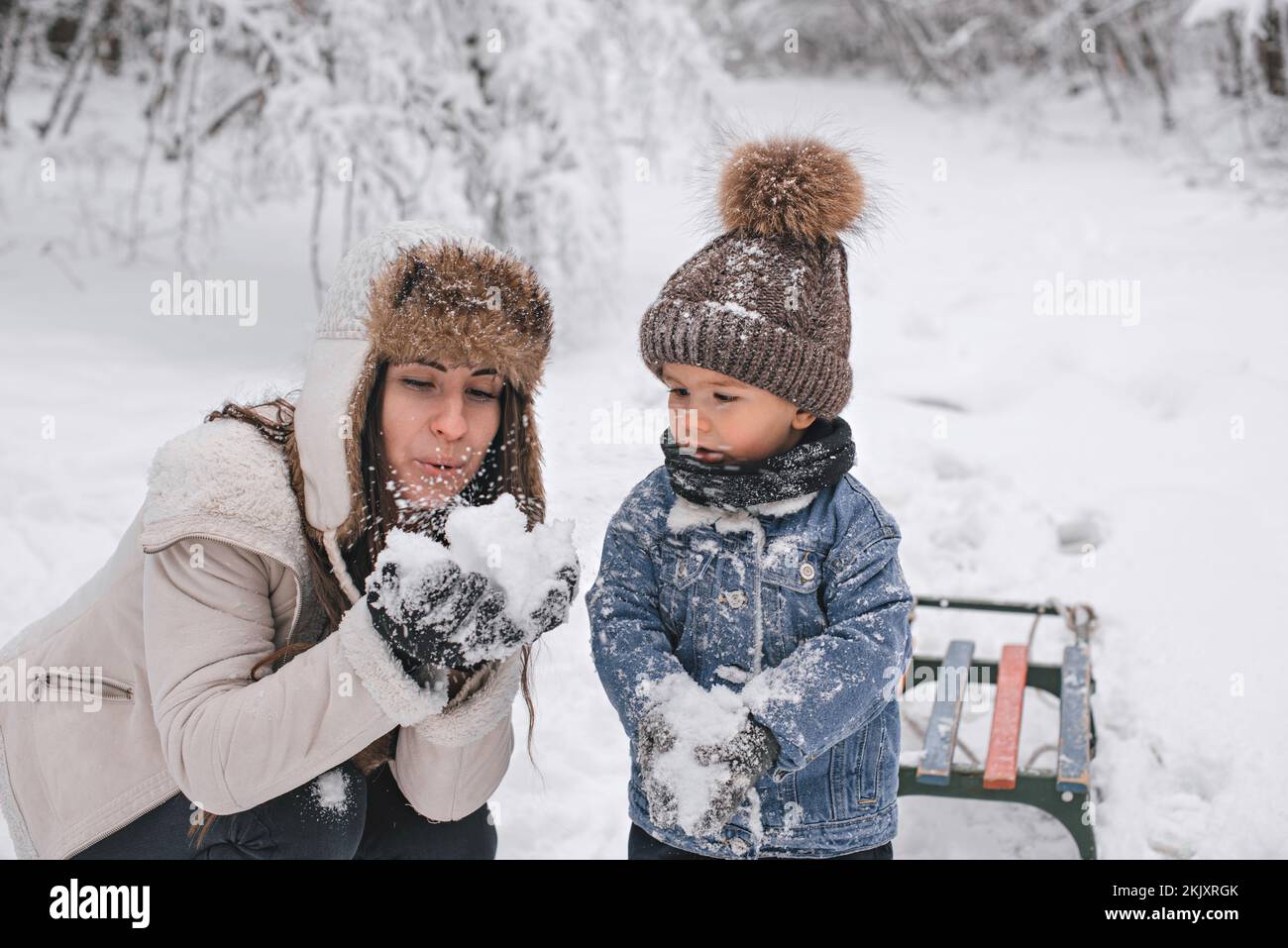 Maman et son fils marchent dans la neige dans la forêt d'hiver. Banque D'Images