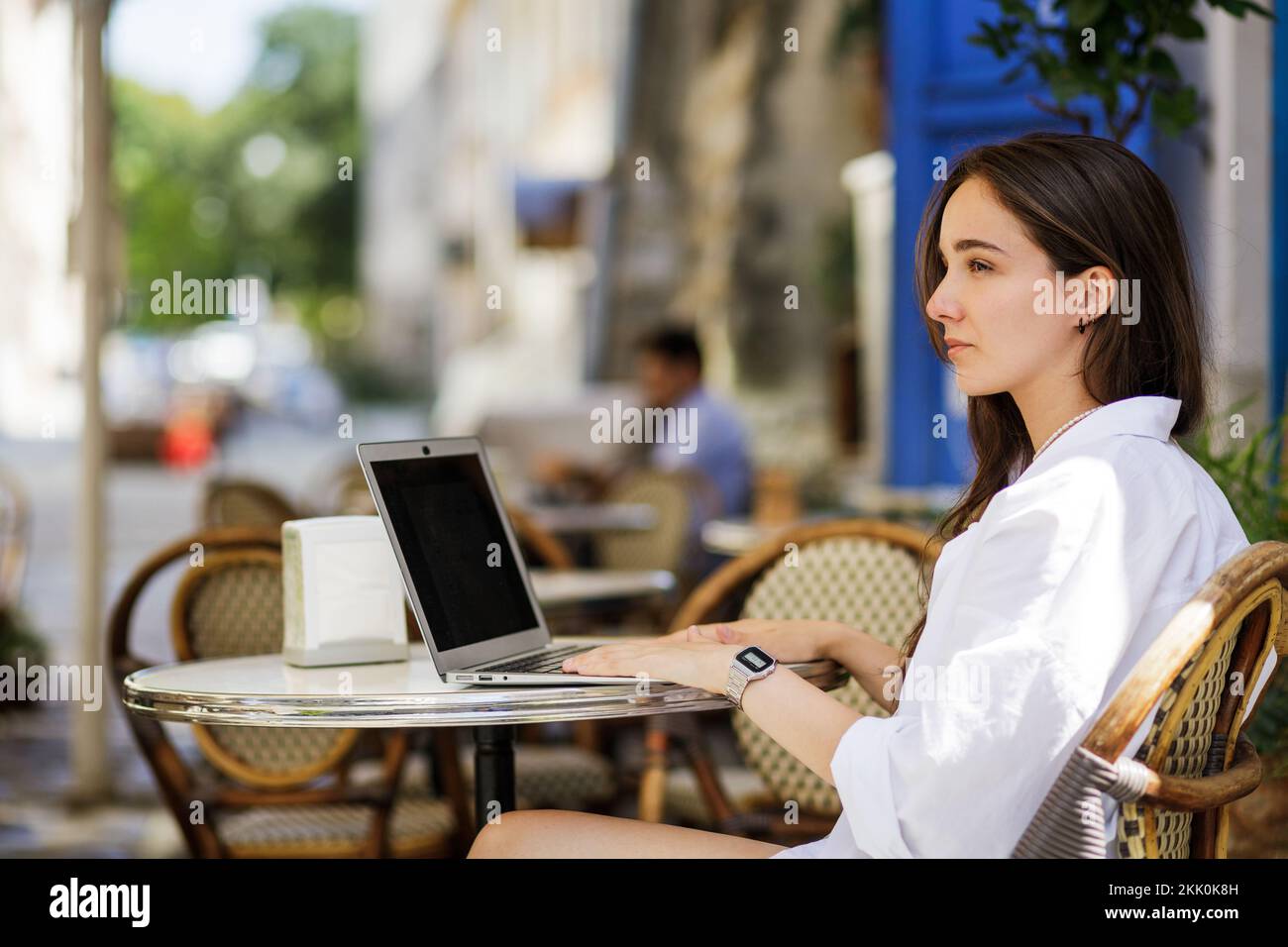 Jeune femme en chemise blanche utilisant son ordinateur portable pour l'éducation en ligne Banque D'Images