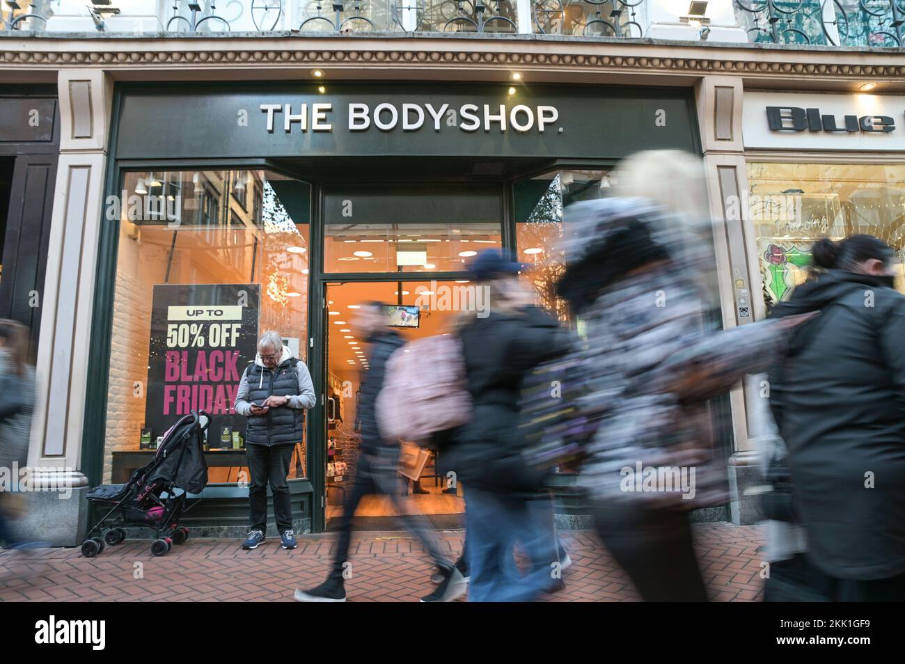 New Street, Birmingham le 25 novembre 2022. - Un homme attend devant le Body Shop dans le centre-ville de Birmingham pendant que sa famille regarde les offres à l'intérieur le vendredi noir. Pic by Credit : Stop Press MediaAlamy Live News Banque D'Images