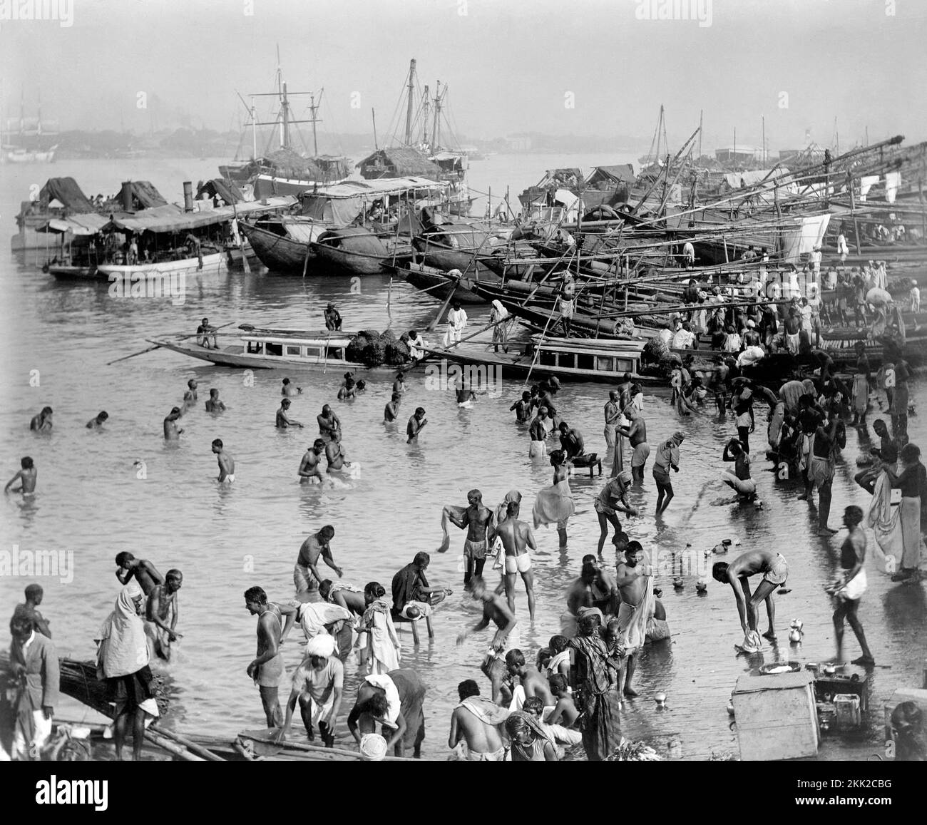 Scène de port bondée en Thaïlande avec la plupart des hommes et des garçons se baignant parmi les bateaux de pêche. Banque D'Images