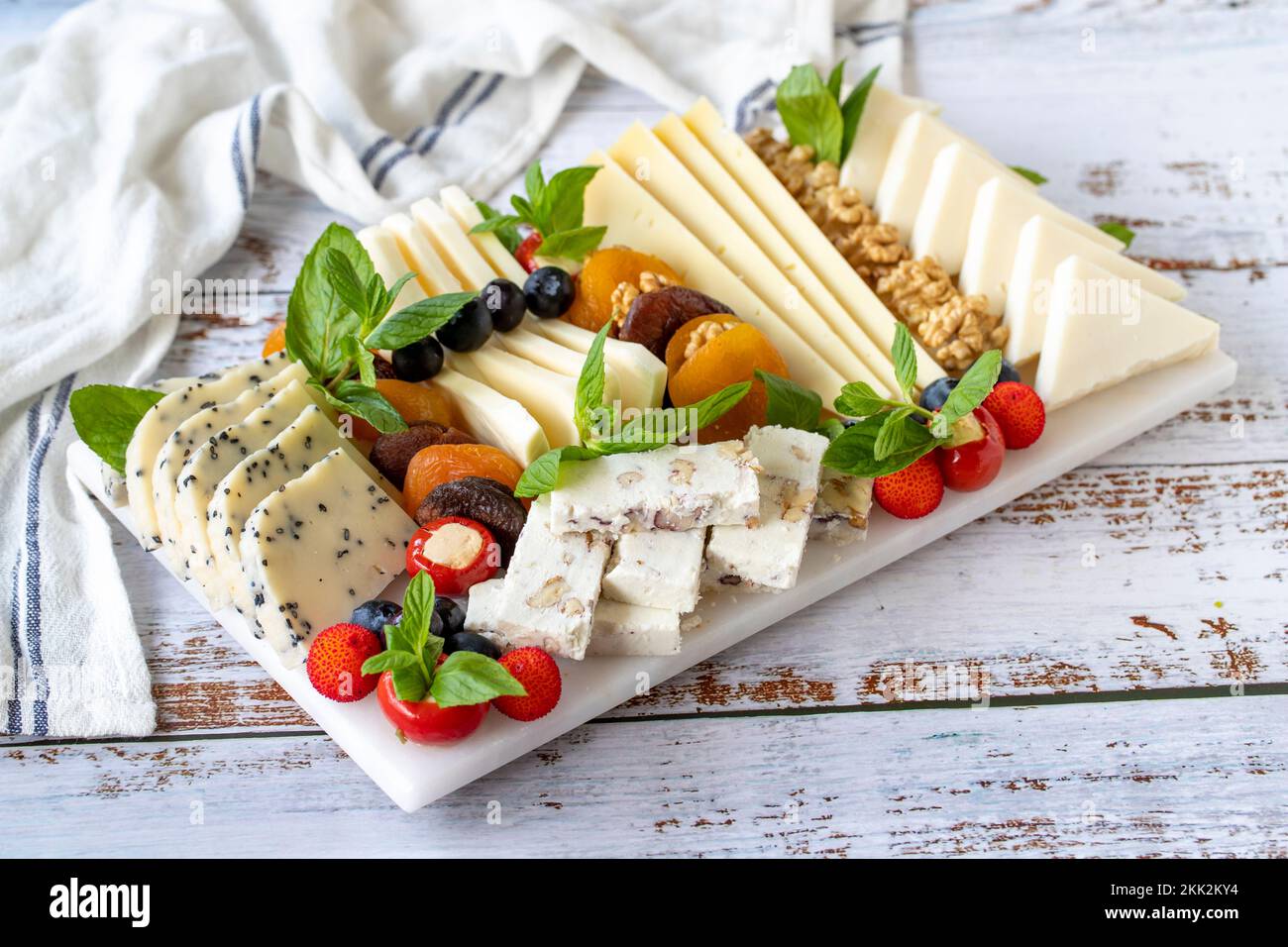 Assiette de fromages mélangés sur parquet. Délicieux assortiment de fromages. Camembert, Brie, parmesan, chèvre Banque D'Images