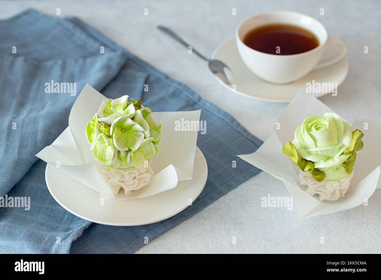 ensemble de thé dans une composition avec des fleurs de guimauve. Tasse à café sur soucoupe. Sur fond gris clair. Soirée thé revigorante le matin Banque D'Images