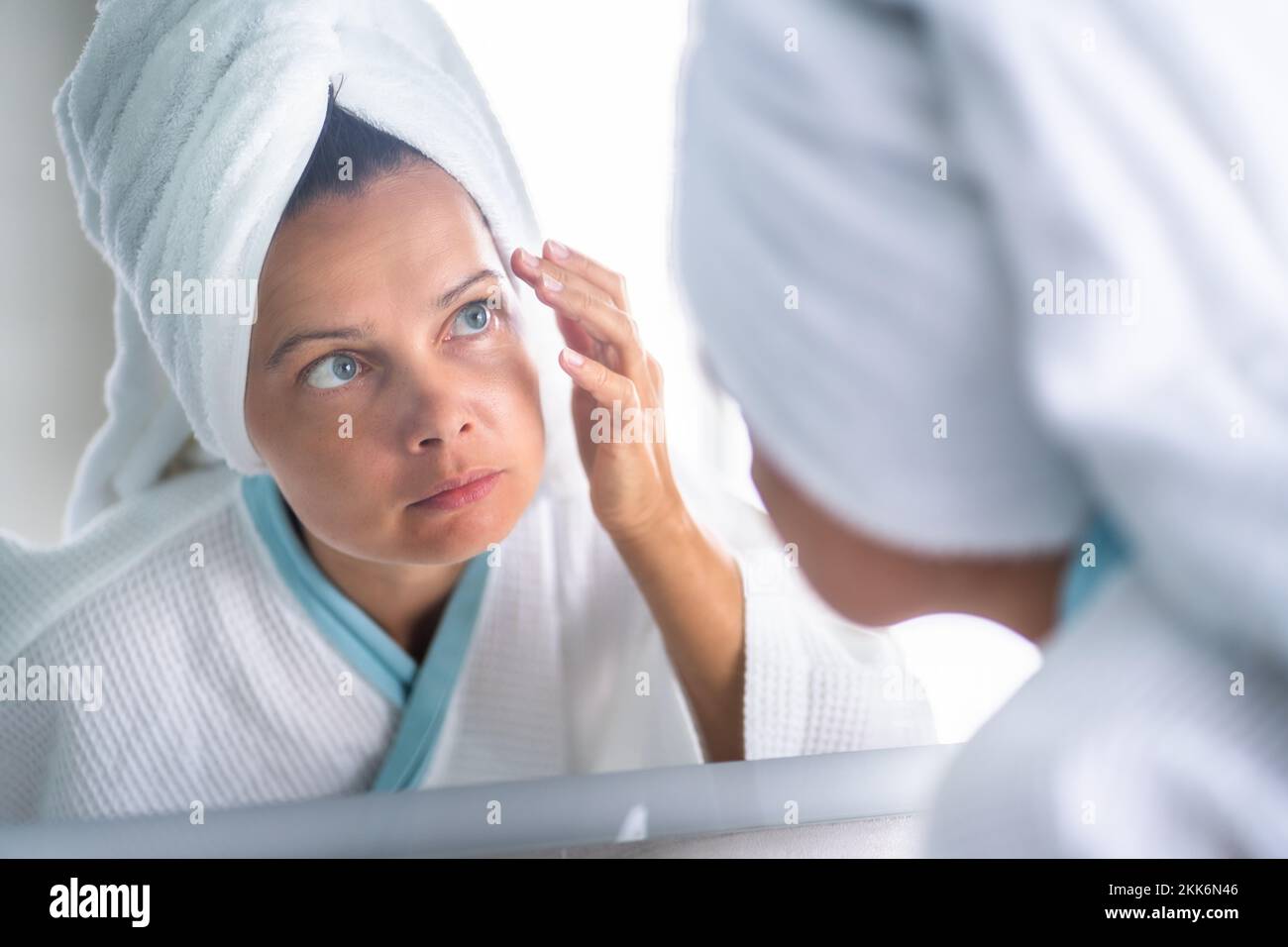 Femme appuyant le bouton sur son visage. Problème de peau d'acné Banque D'Images