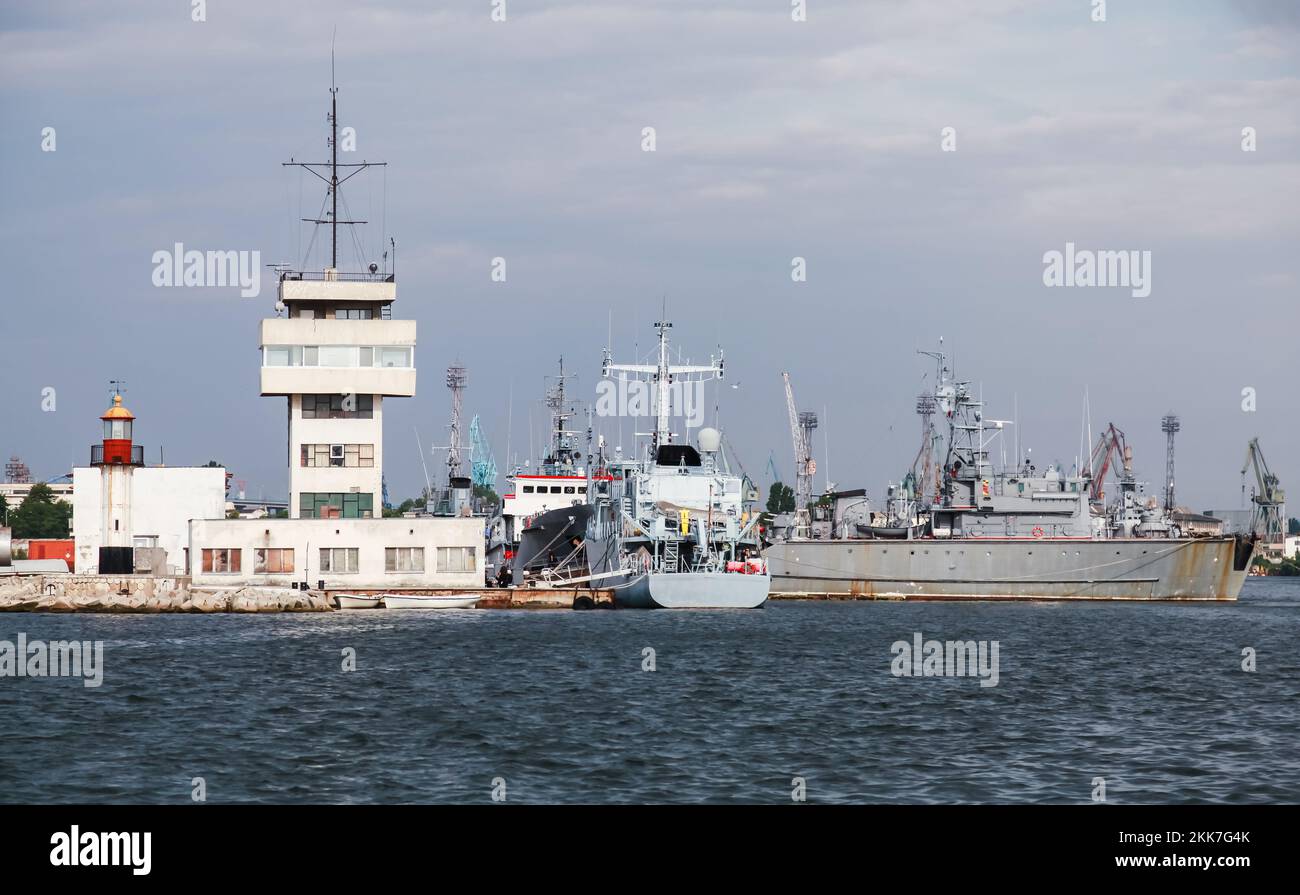 Port de Varna, Bulgarie. Paysage côtier avec tour de contrôle de la circulation maritime, phare et navires de la Marine bulgare amarrés Banque D'Images