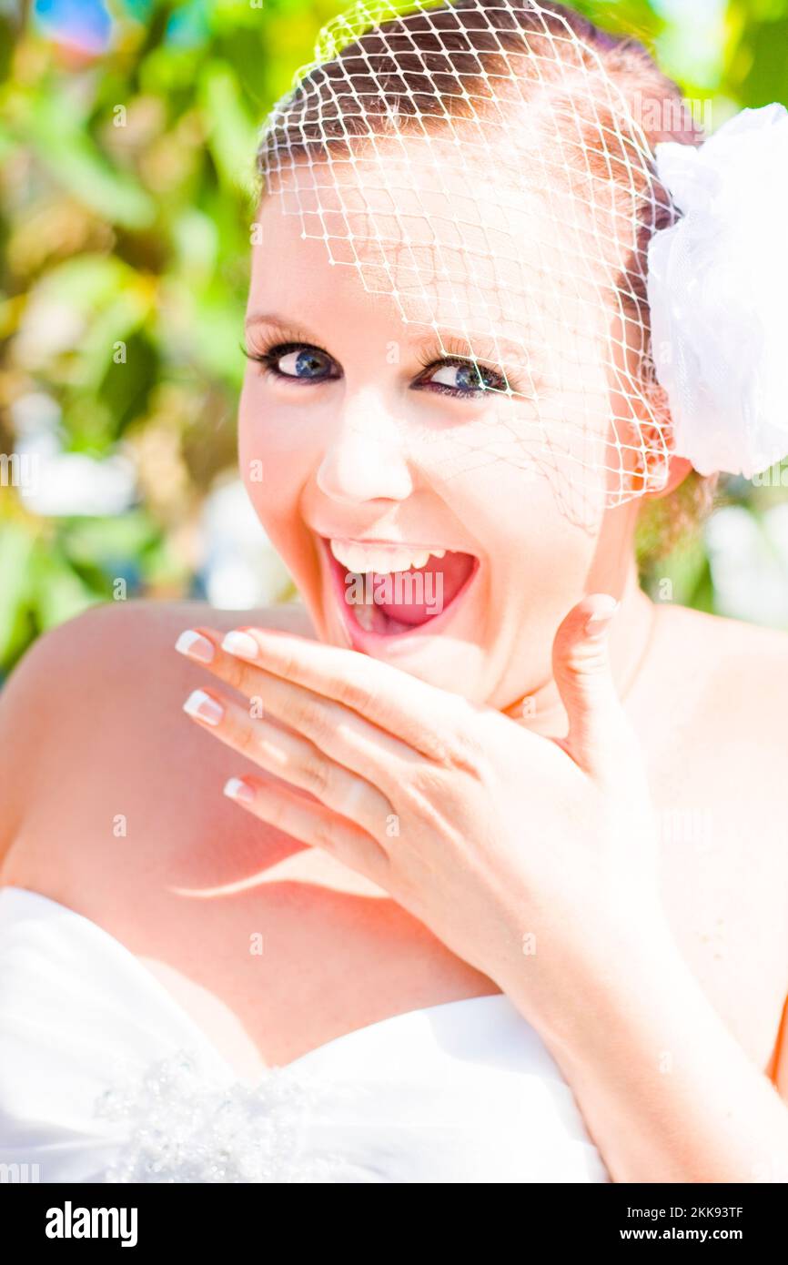 Jeune belle mariée à l'œil bleu qui regarde extatique et joyeuse sur elle  Jour de mariage avec manucure française et voile de cage d'oiseaux avec  Arrière-plan extérieur Photo Stock - Alamy