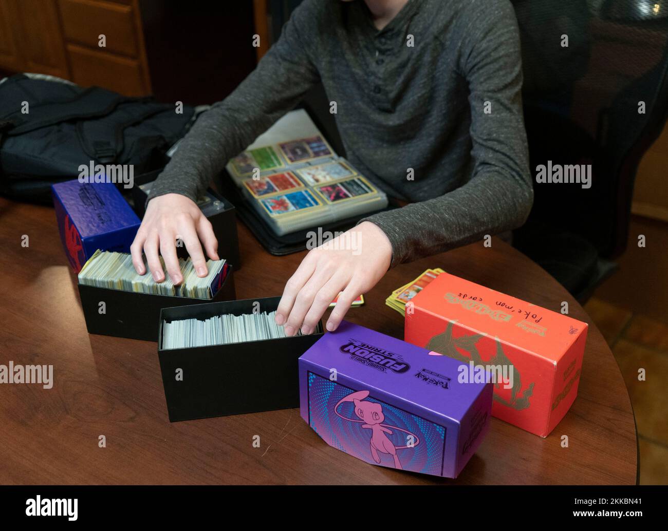 Austin Texas Etats-Unis, 24 novembre 2022: Garçon de 14 ans trie sa collection de cartes Pokémon pendant une pause dans les activités de Thanksgiving dîner dans la maison d'un parent. ©Bob Daemmrich Banque D'Images
