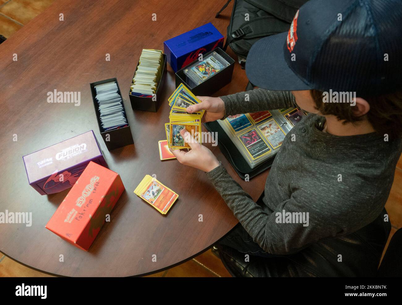 Austin Texas Etats-Unis, 24 novembre 2022: Garçon de 14 ans trie sa collection de cartes Pokémon pendant une pause dans les activités de Thanksgiving dîner dans la maison d'un parent. ©Bob Daemmrich Banque D'Images