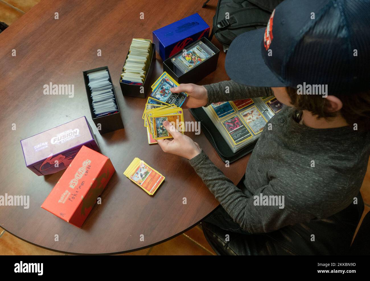 Austin Texas Etats-Unis, 24 novembre 2022: Garçon de 14 ans trie sa collection de cartes Pokémon pendant une pause dans les activités de Thanksgiving dîner dans la maison d'un parent. ©Bob Daemmrich Banque D'Images