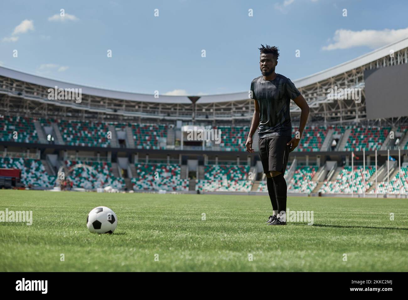 Football masculin professionnel, joueur de football sur fond de stade. Athlète africain de la forme s'entraînant, jouant excité Banque D'Images