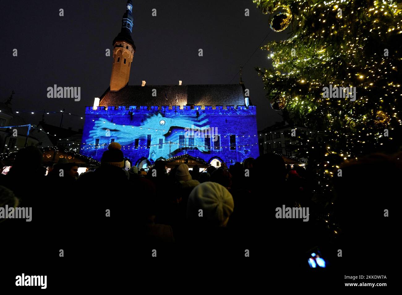 Les gens voient un spectacle de lumière sur le mur de l'hôtel de ville pendant le marché de Noël à Tallinn, Estonie 25 novembre 2022. REUTERS/Ints Kalnins Banque D'Images