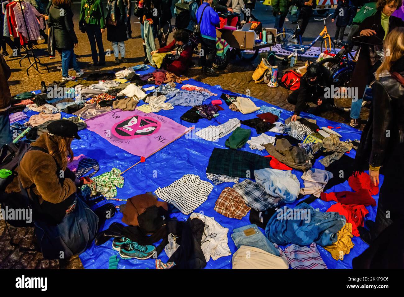 Amsterdam, pays-Bas. 25th novembre 2022. Les gens prennent des vêtements de seconde main gratuitement lors de la manifestation de la rébellion du Vendredi fou. L'organisation pour le climat, extinction Rebellion (XR) a organisé une manifestation contre la surconsommation pendant le Vendredi fou, et pour mettre fin à ce jour. Les activistes ont mené une action appelée Free (ky) Friday sur la place du Dam où ils ont placé des centaines de vêtements de seconde main que les gens pouvaient emporter gratuitement ou échanger des vêtements. Avec cette action, l'organisation veut placer le profit au-dessus des personnes et de la planète et rompre avec la culture du consommateur. Accordent Banque D'Images