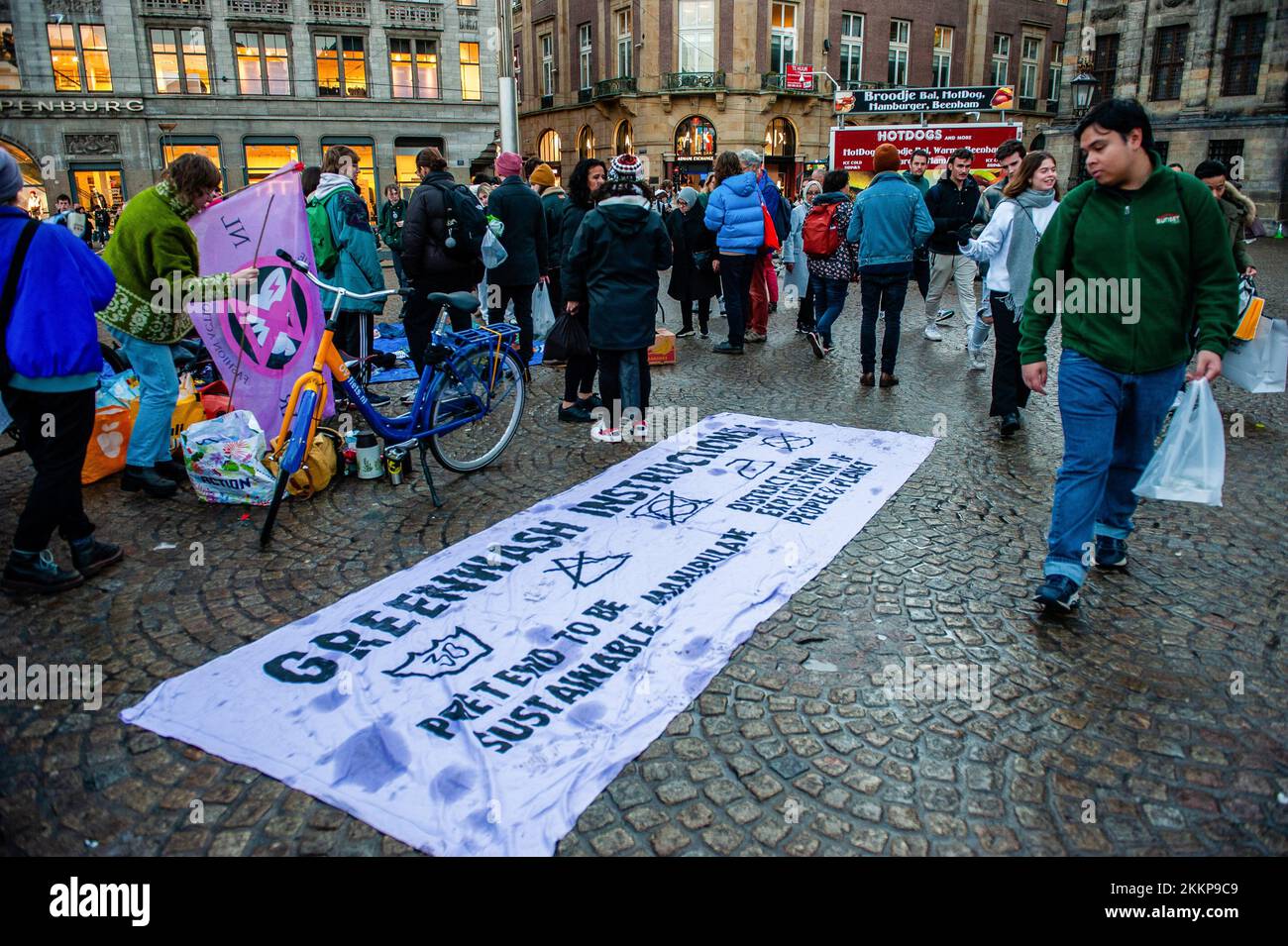 Amsterdam, pays-Bas. 25th novembre 2022. Un homme regarde une grande  bannière placée sur le sol contre le verdwash dans l'industrie de la mode  pendant la démonstration de la rébellion d'extinction du Vendredi