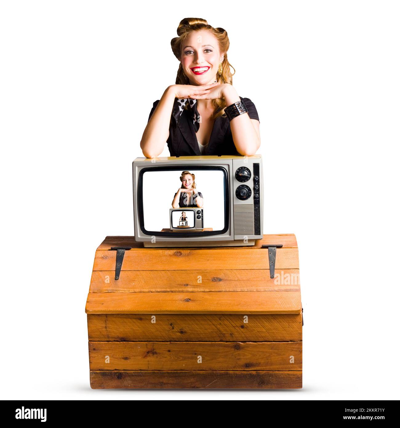 Femme devant une caméra TV invisible avec elle image affichée sur un moniteur de télévision placé sur le une poitrine de pin poli isolée sur le dos blanc Banque D'Images