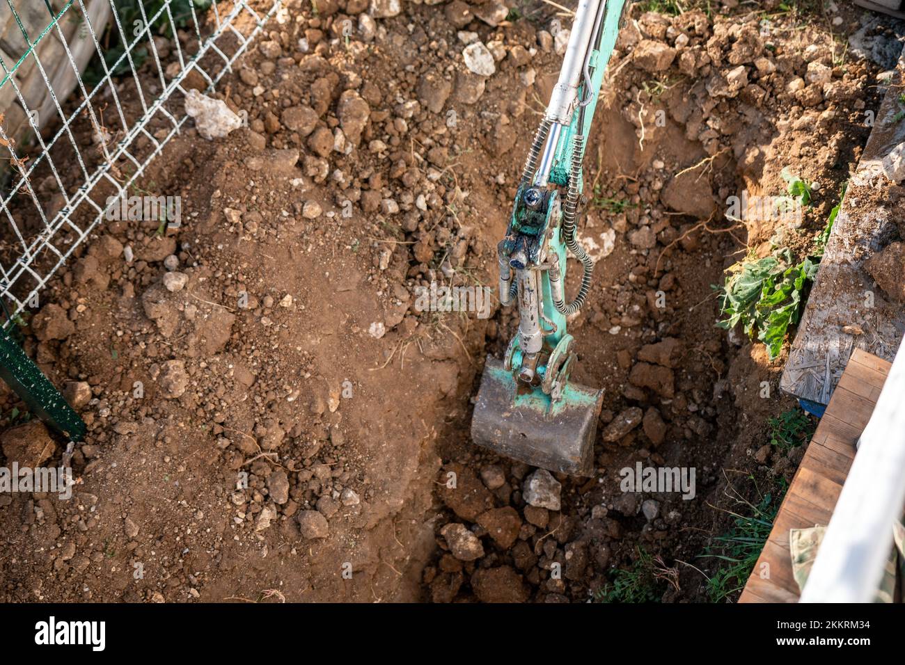 Une minipelle creuse une tranchée pour poser les tuyaux. Gros plan d'une pelle hydraulique creusant une tranchée profonde. Une pelle hydraulique creuse une tranchée dans la campagne pour déposer un Banque D'Images
