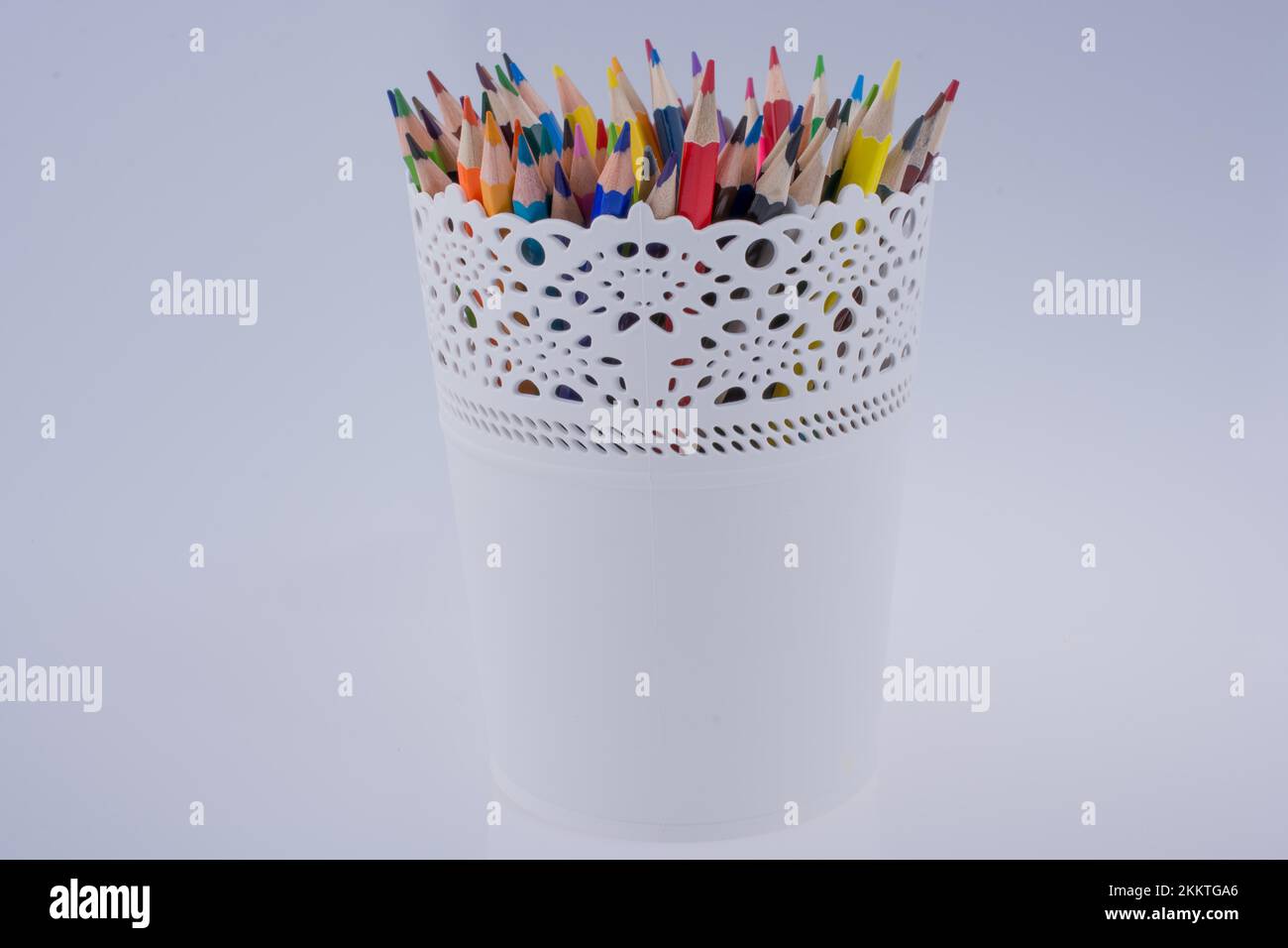Crayons de couleur dans un vase sur un fond blanc Photo Stock - Alamy
