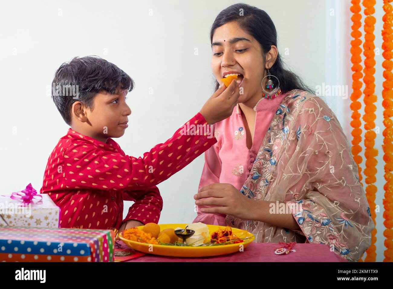 Frère nourrissant des ladoos à sa sœur à l'occasion de Raksha Bandhan Banque D'Images