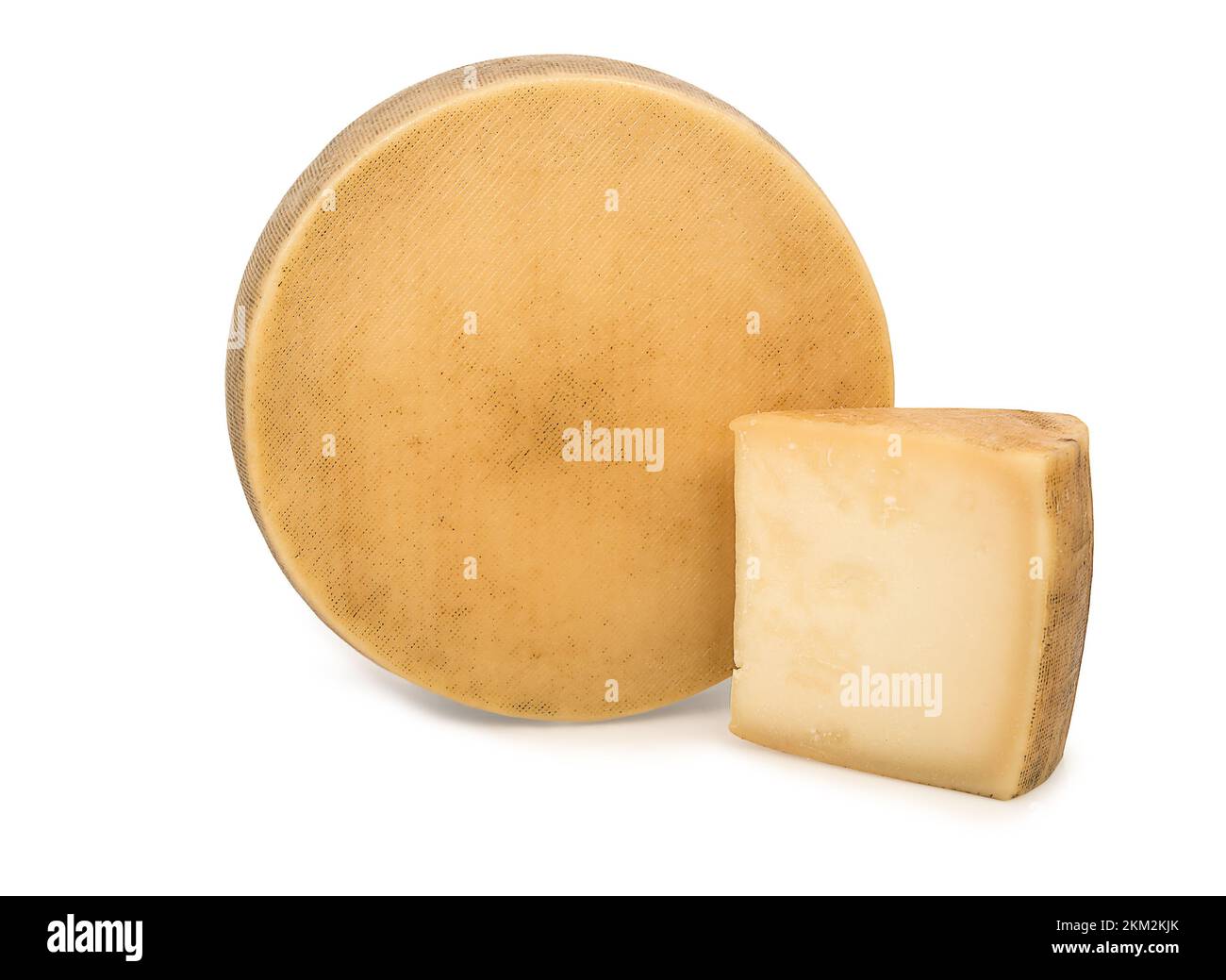 Fromage texturé dans sa croûte à côté d'un coin de fromage. Banque D'Images