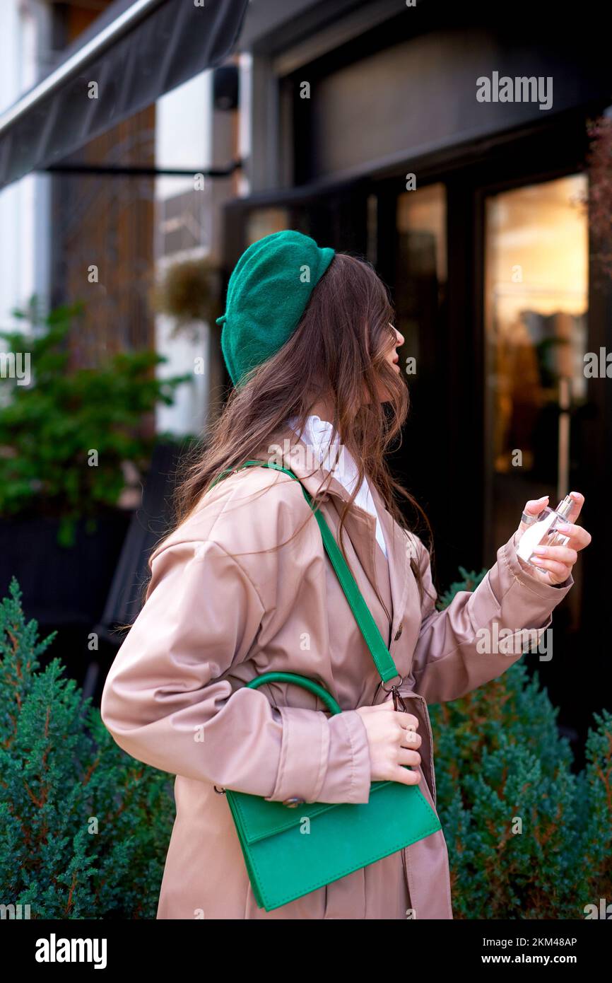 femme le jour de l'automne s'amusant dans la rue portant une tenue élégante et un béret vert Banque D'Images