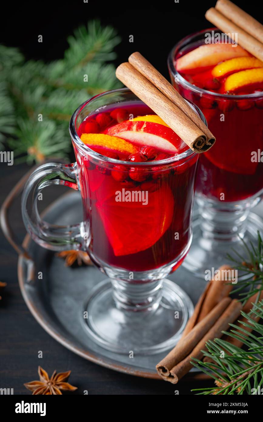 Deux verres avec vin chaud chaud chaud, orange et épices sur fond de bois. Banque D'Images