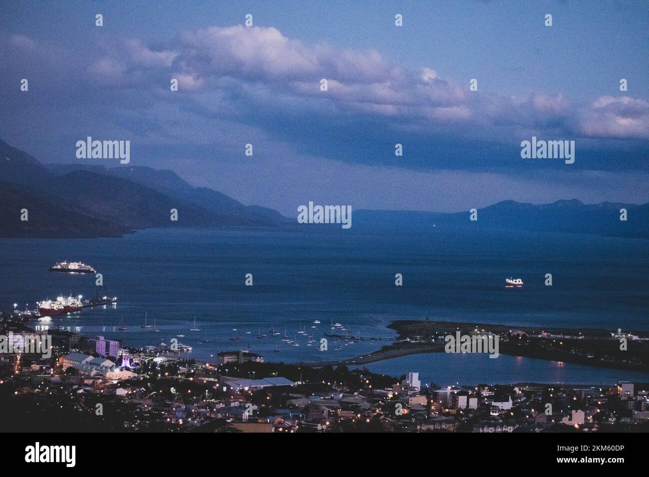 La ville d'Ushuaia, en Argentine, la nuit, où le port rencontre la ville et les montagnes en arrière-plan. Banque D'Images