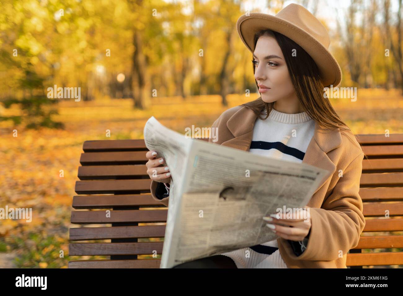 Une fille attirante lit un journal dans le parc. Surveillance le détective privé surveille l'objet.agent de renseignement attrayant Banque D'Images
