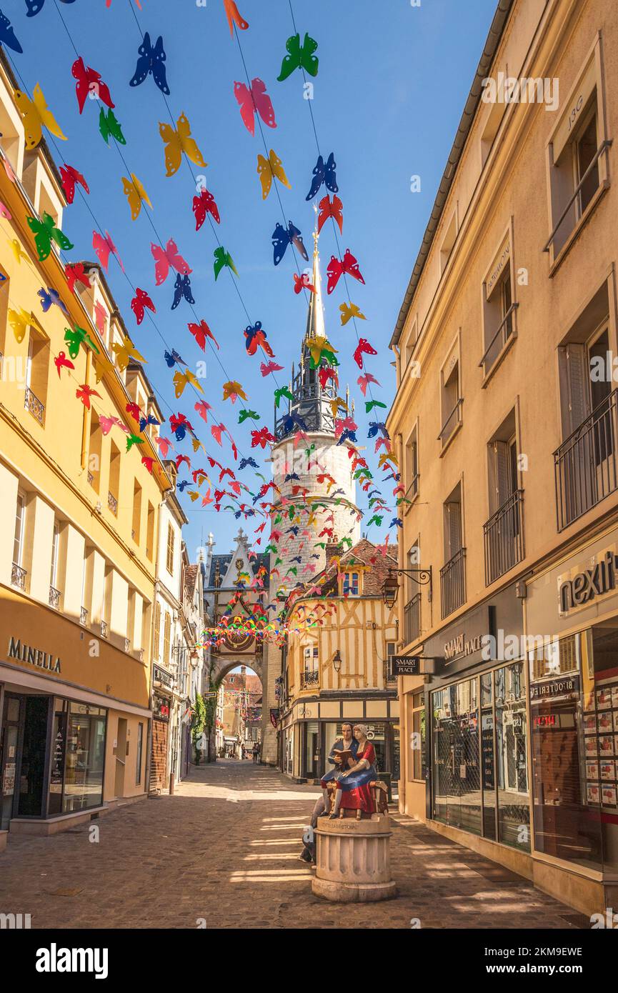 La rue de l’horloge dans la vieille ville d’Auxerre, en France, avec la tour “Tour de l’horloge” et la statue de Nicolas Retif de la Breton Banque D'Images