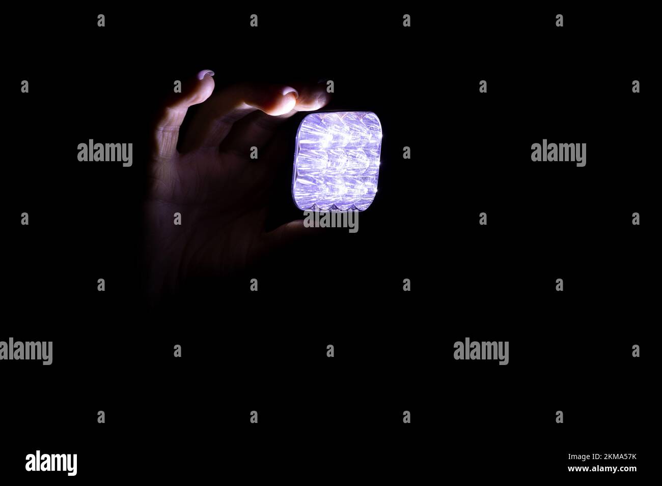 Un phare sur la tête d'une fille dans l'obscurité à la maison, Ukraine sans lumière, attaque de missile, pannes Banque D'Images