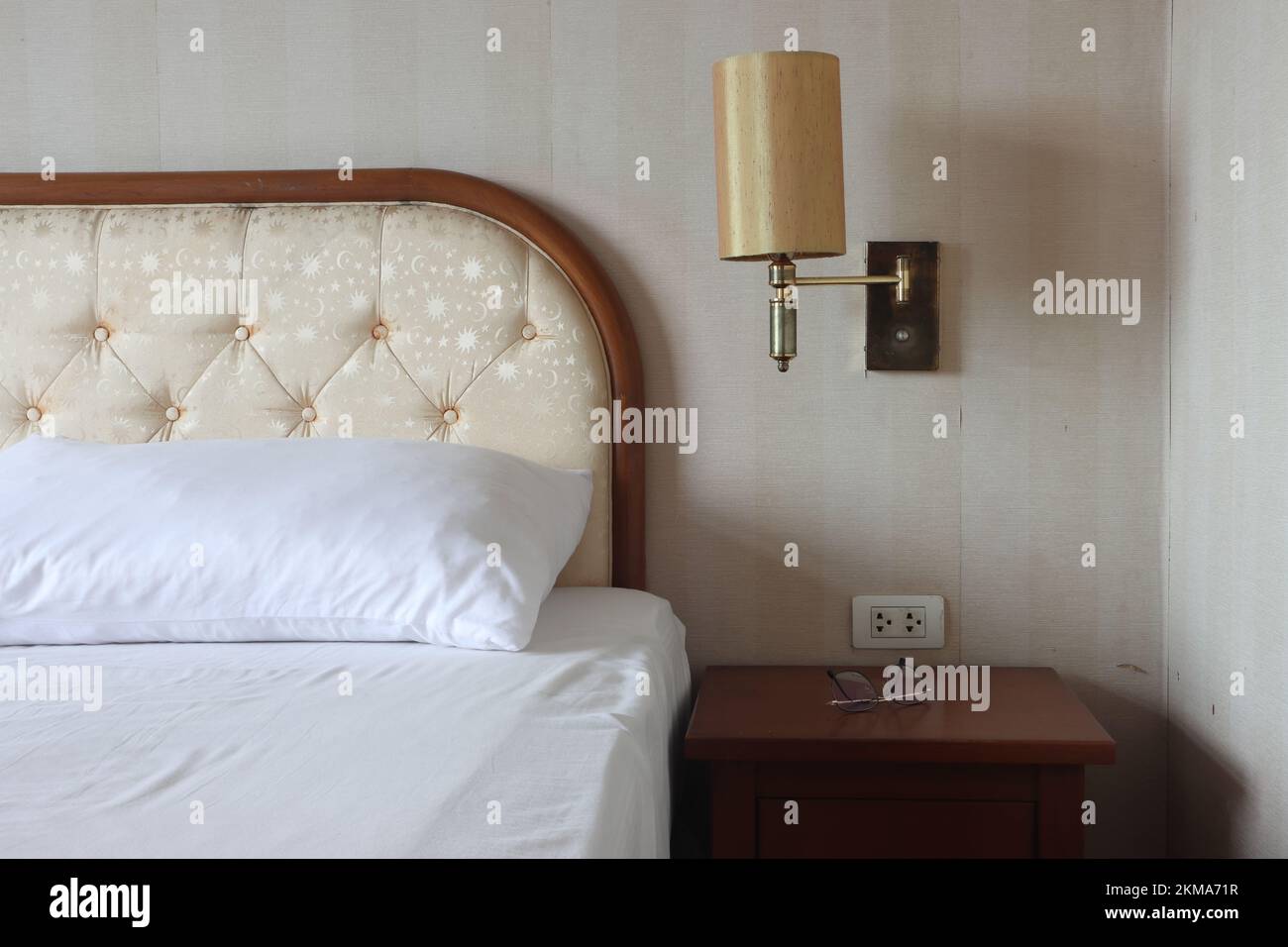 Un lit avec une lampe suspendue au-dessus de la table de chevet Photo Stock  - Alamy
