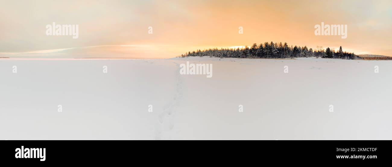 Panorama d'hiver de l'île dans la mer blanche gelée pendant le beau lever du soleil. Paysage de nature artique Banque D'Images