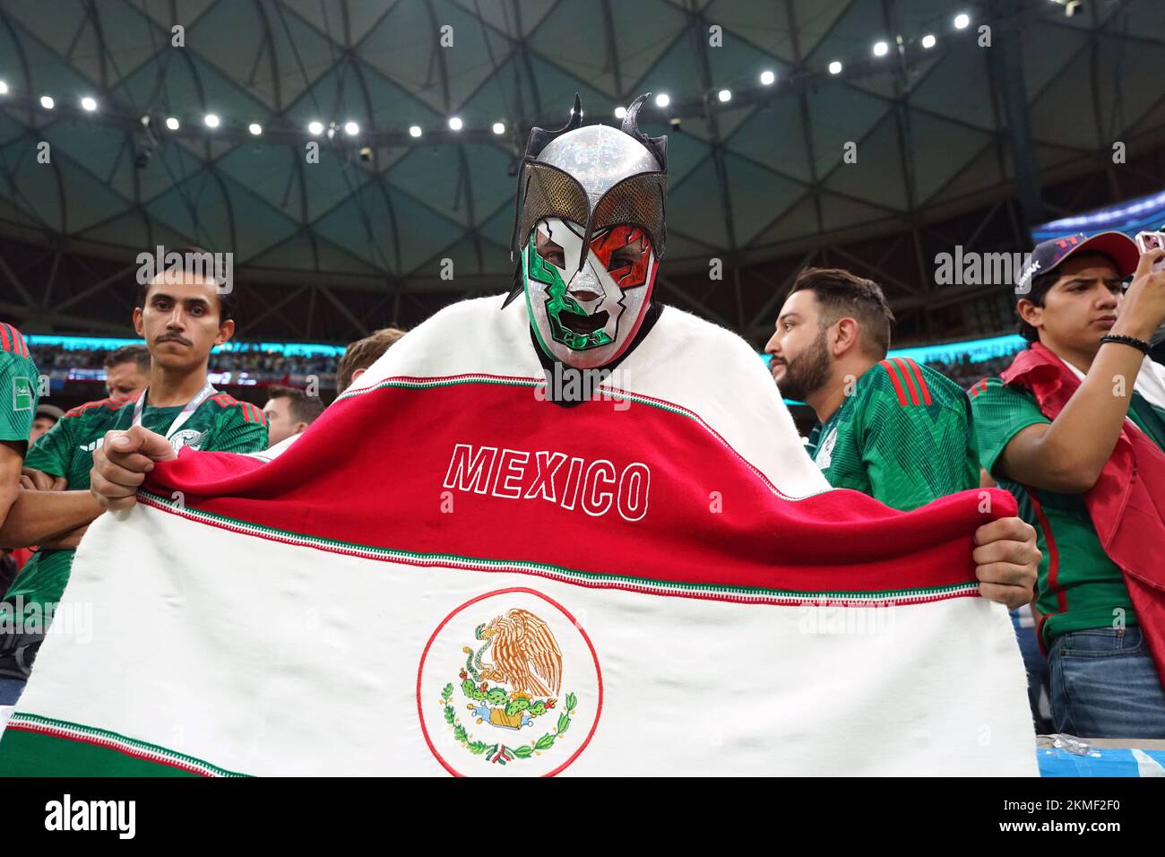 Un fan mexicain portant un masque et portant un drapeau pendant le match de la coupe du monde de la FIFA du groupe C au stade Lusail à Lusail, au Qatar. Date de la photo: Samedi 26 novembre 2022. Banque D'Images