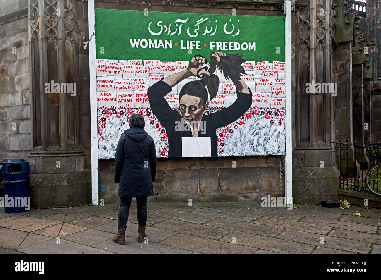 Femme regardant la fresque « Women Life Freedom » à l'église St John's, Princes Street, Édimbourg, Écosse, Royaume-Uni. Banque D'Images