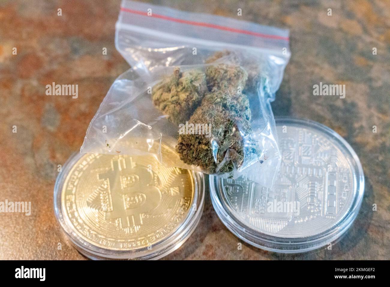 Pièce de monnaie en or physique à crypto-monnaie avec un signe bleu sur le cannabis Banque D'Images