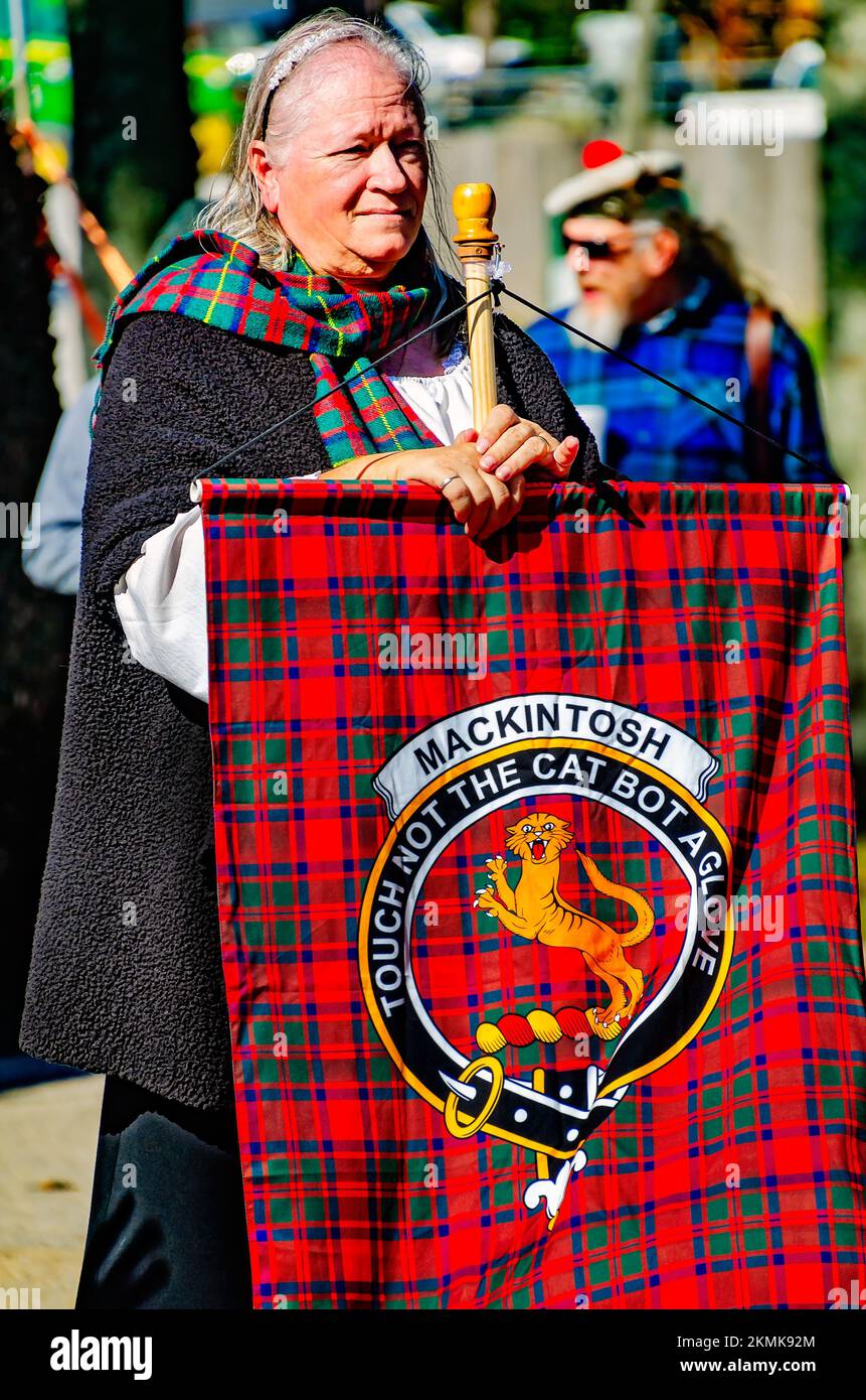 Une femme tient un tartan représentant le clan Mackintosh lors de la parade des tartans du clan aux Jeux écossais des Highlands à Gulfport, Mississippi. Banque D'Images