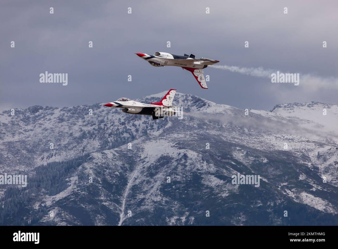 Une paire de Thunderbirds de l'US Air Force en formation serrée avec la chaîne enneigée de Wasatch en arrière-plan, Hill Air Force base, Utah Banque D'Images