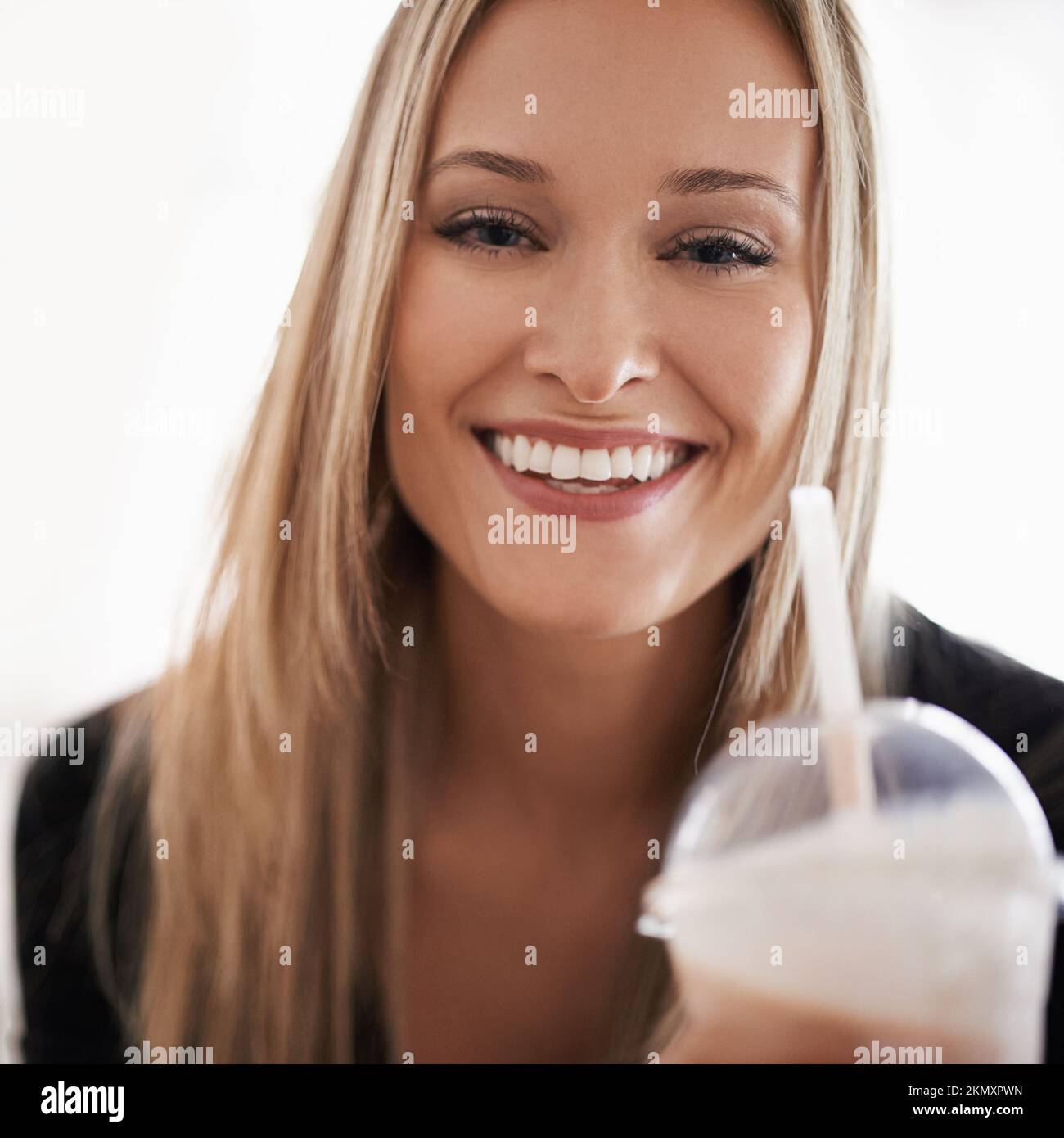 J'aime mes milk-shakes. Portrait d'une jeune femme buvant un milk-shake à la maison. Banque D'Images