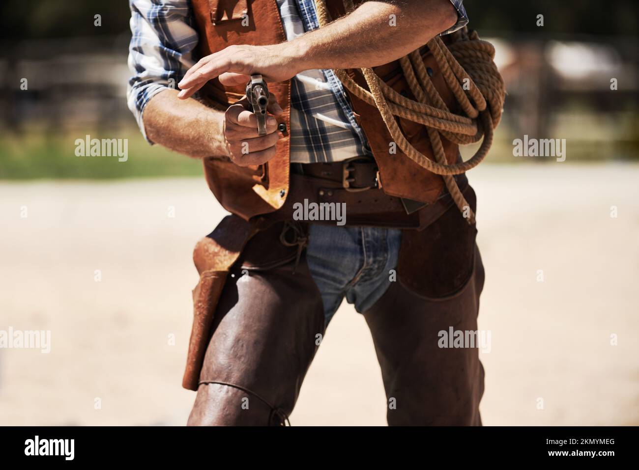 Son tirage au sort a été rapide. un cowboy méconnaissable avec son fusil tiré. Banque D'Images