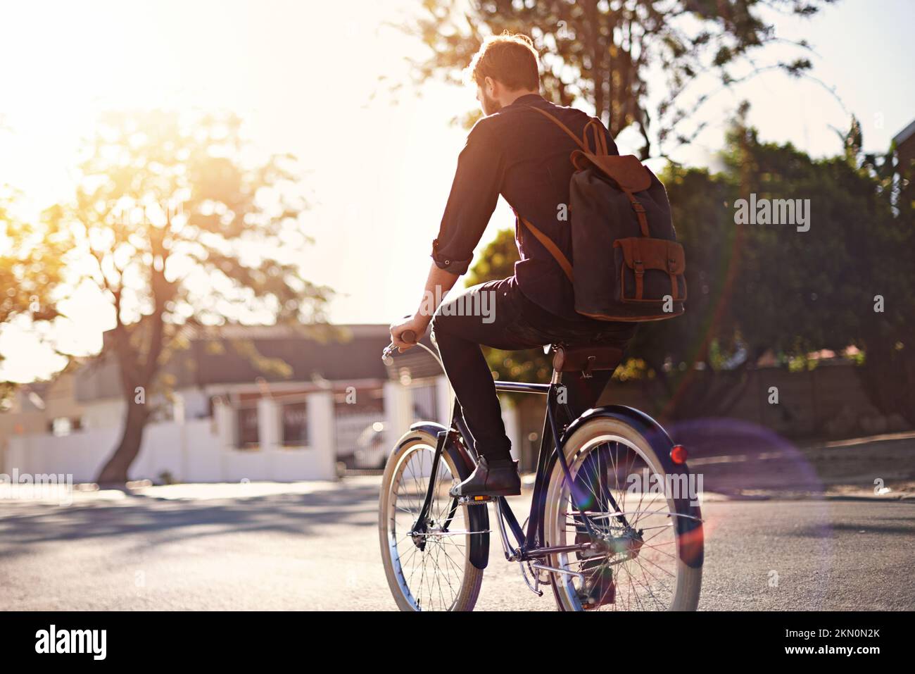 Je préfère être à cheval. Vue arrière d'un jeune homme à vélo en plein air. Banque D'Images