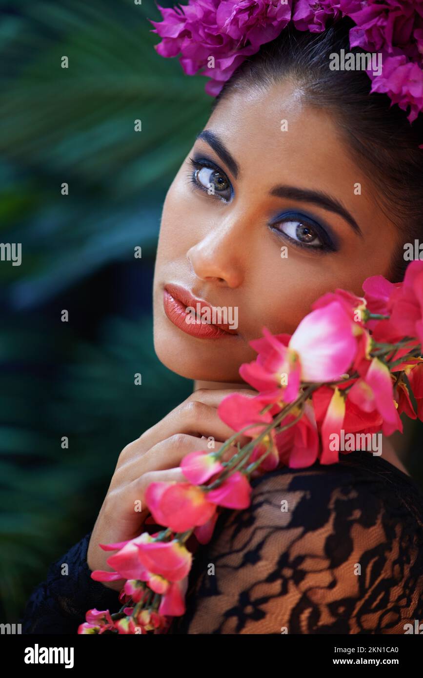 Les yeux qui hypnotisent. Un portrait d'une belle femme portant des fleurs colorées. Banque D'Images