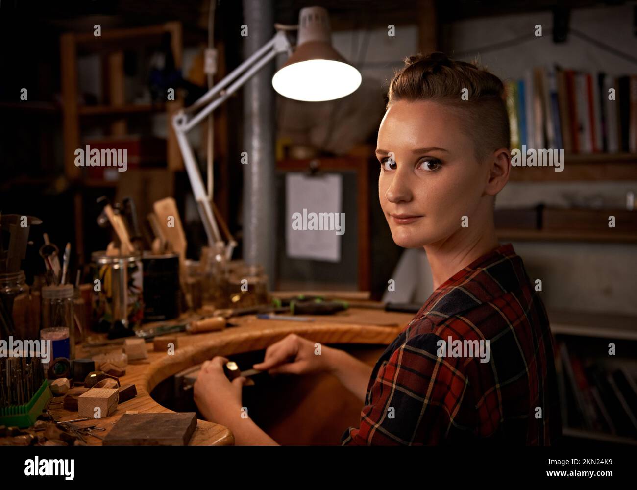 Sérieux au sujet de mon passe-temps. une belle jeune femme assise dans un atelier. Banque D'Images