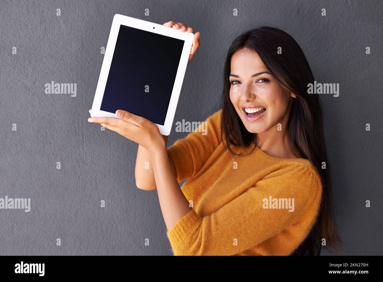 Des technologies fraîches faciles à transporter. Portrait d'une jeune femme attrayante tenant une tablette numérique avec un écran vierge. Banque D'Images