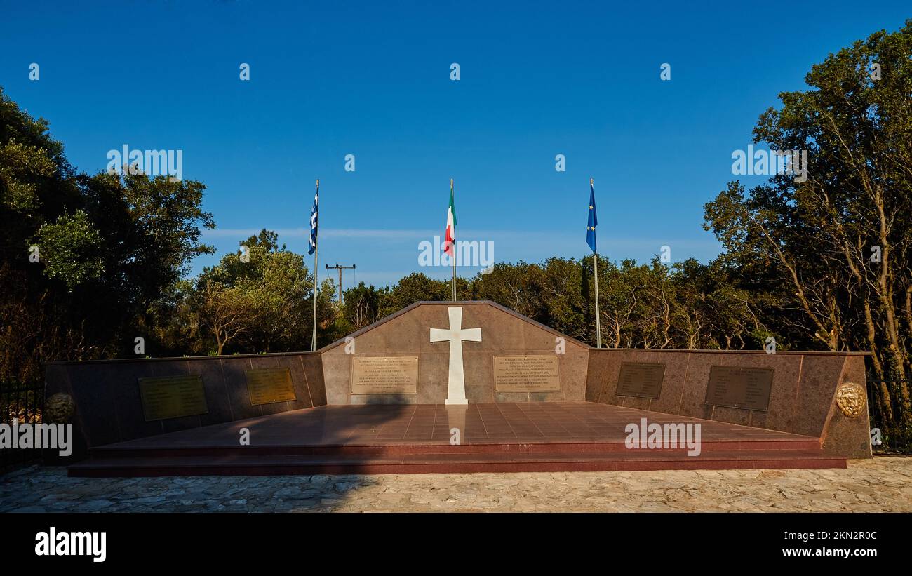 War Memorial Acqui, grande croix blanche, drapeau national grec, drapeau national italien, drapeau européen, Arbres, ligne électrique retouchée, île de Kefalonia, Ionia Banque D'Images
