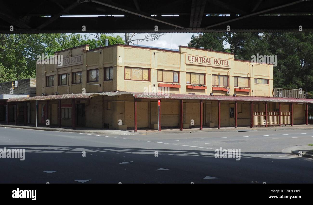 Le Central Hotel est monté et délabré (est. 1878) à Moss Vale, Nouvelle-Galles du Sud. Pont ferroviaire adjacent et son ombre à l'intersection Banque D'Images