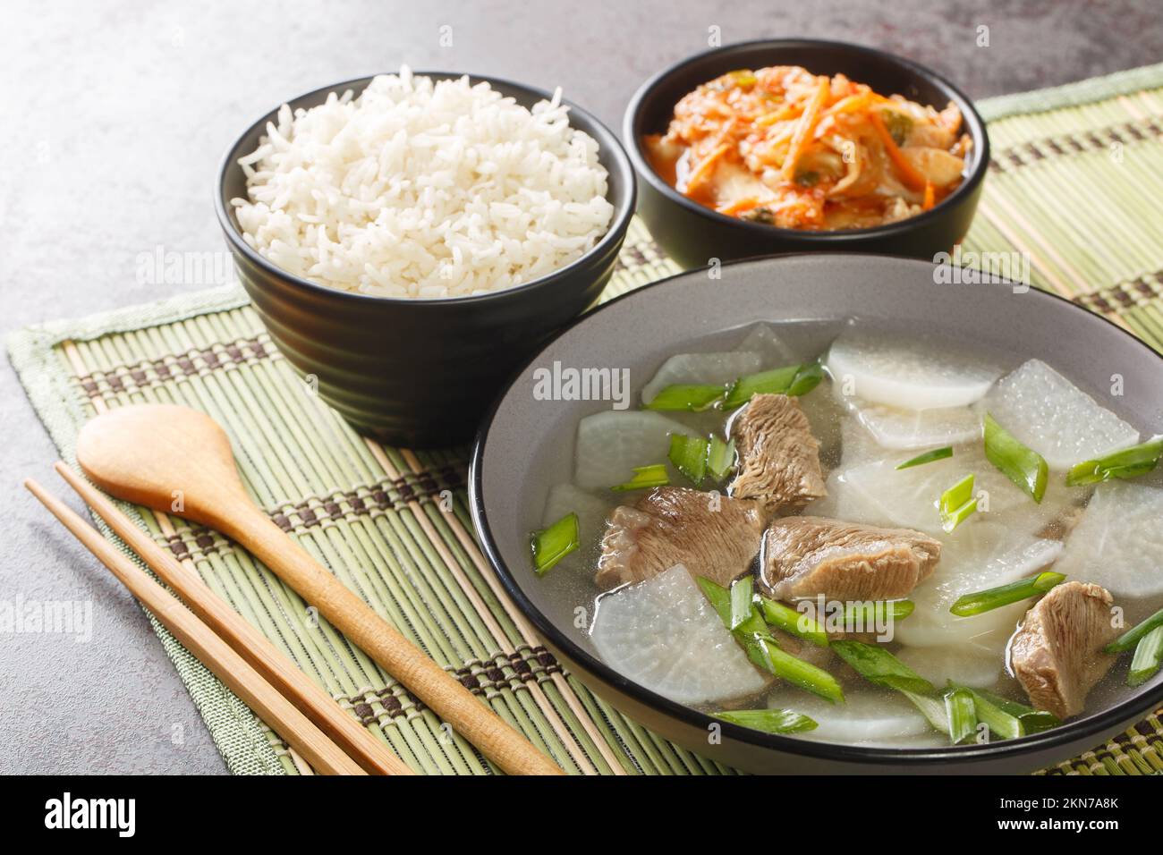 Soupe de radis de bœuf coréen appelée soegogi muguk, servie avec du riz et des kimchi sur le tapis de table. Horizontale Banque D'Images