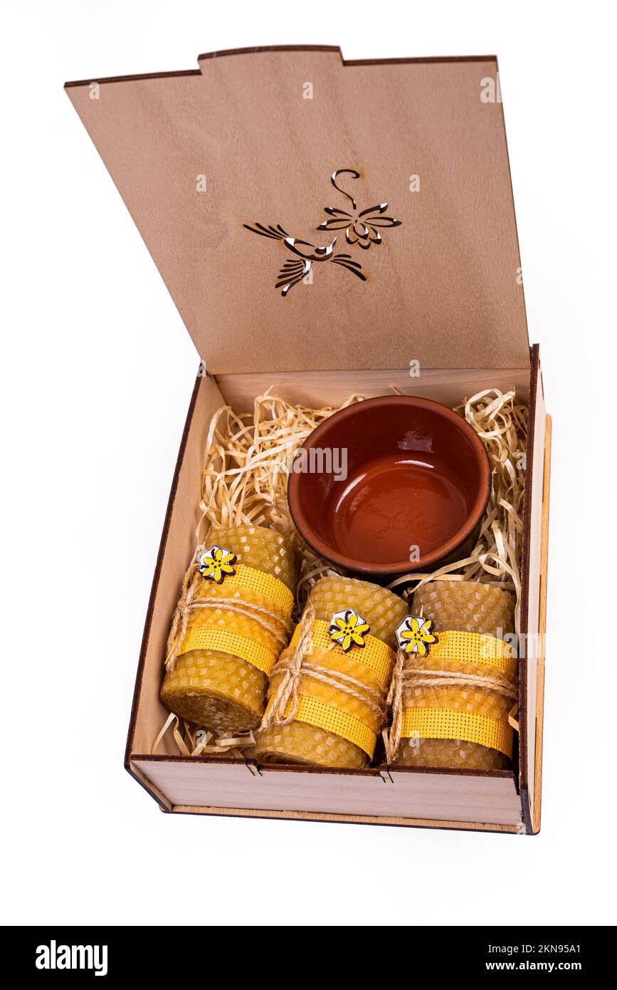 Vitamines et produits biologiques dans le cadeau. Miel dans un pot avec un bâton et des bougies de cire. Cadeau dans une boîte isolée sur blanc Banque D'Images