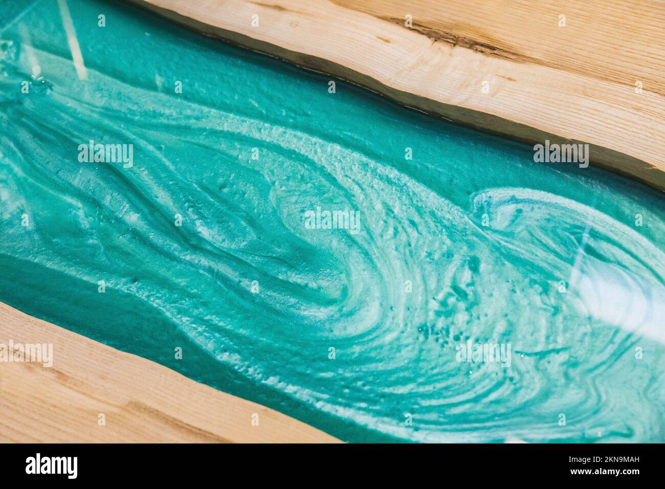 de l'époxy turquoise liquide sur la table de cuisine de l'atelier Banque D'Images