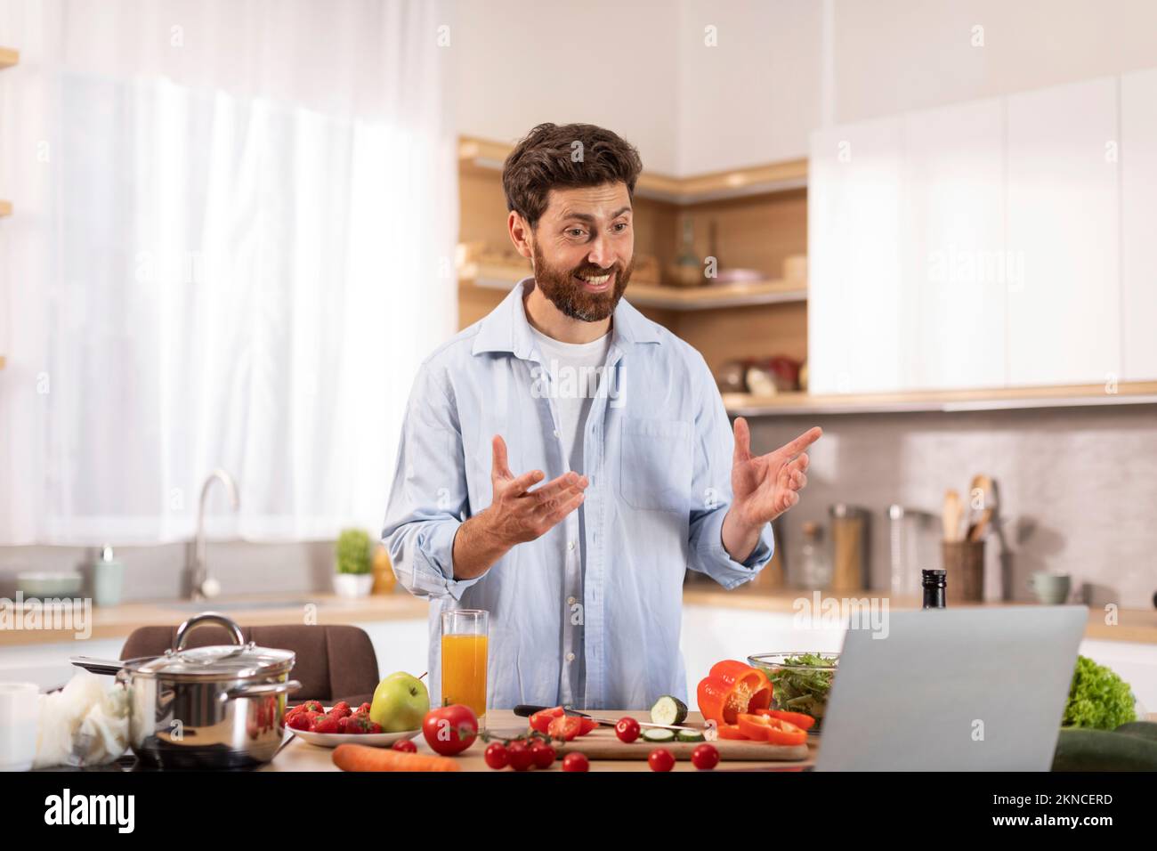 Gai homme de race blanche d'âge moyen avec la barbe a appel vidéo, faire la vidéo pour blog de nourriture, gesturant les mains Banque D'Images