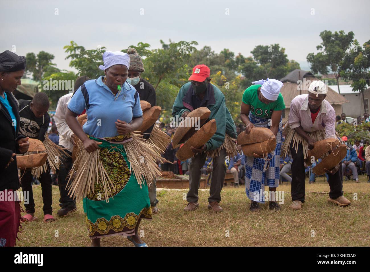 Femme sifflant et dansant devant des musiciens traditionnels exotiques jouant de grands autocollants en bois Banque D'Images