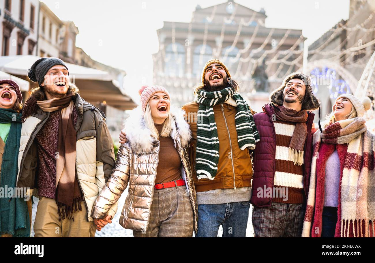 Groupe d'étudiants heureux marchant dans la ville européenne le jour d'hiver ensoleillé - Next gen z concept de style de vie avec des jeunes multiraciaux portant des vêtements chauds Banque D'Images