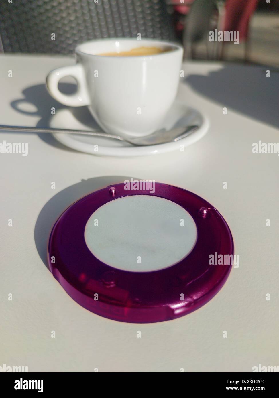 Lecteur de pageur de montagnes russes près d'une tasse de café sur la terrasse. Dispositif de communication sans fil pour les clients du restaurant Banque D'Images