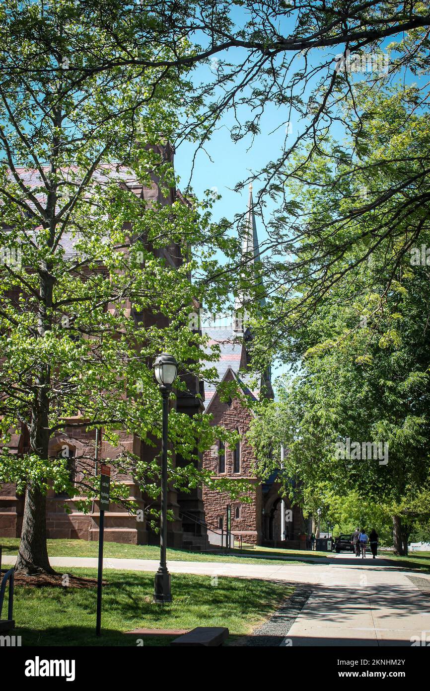 04-24-2015 Middletown USA campus de l'Université Wesleyan - trottoir par église avec arbres et lumière de vapeur et personnes marchant à distance - vertical Banque D'Images